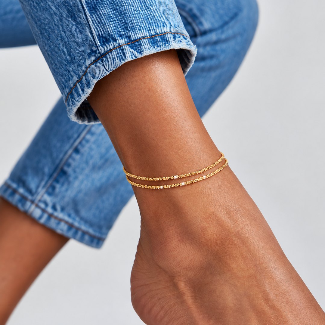 Gold AMORA anklet worn with cropped denim