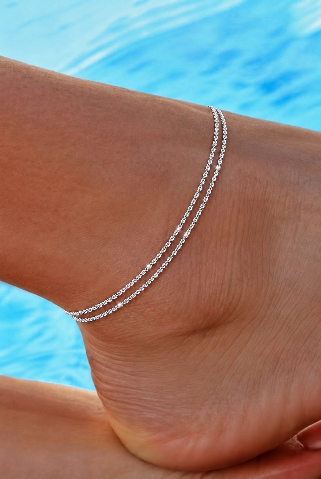 Silver AMORA anklet worn by the pool